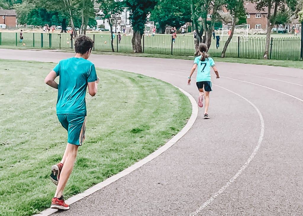 Boy and girl running on a running track