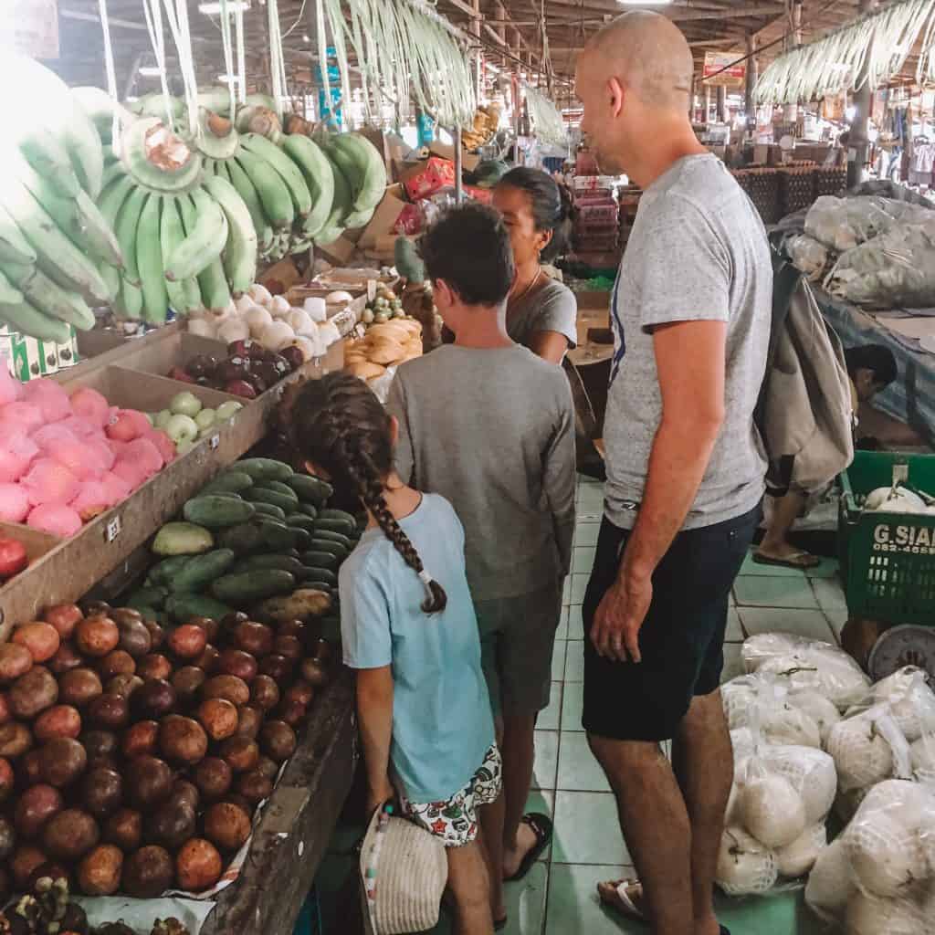 Man with a boy and girl shopping at a Thai market