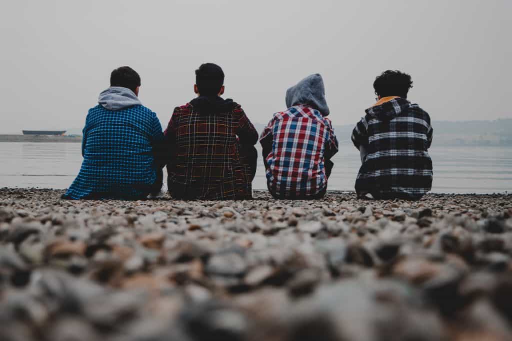 Four boys sitting down looking out to sea