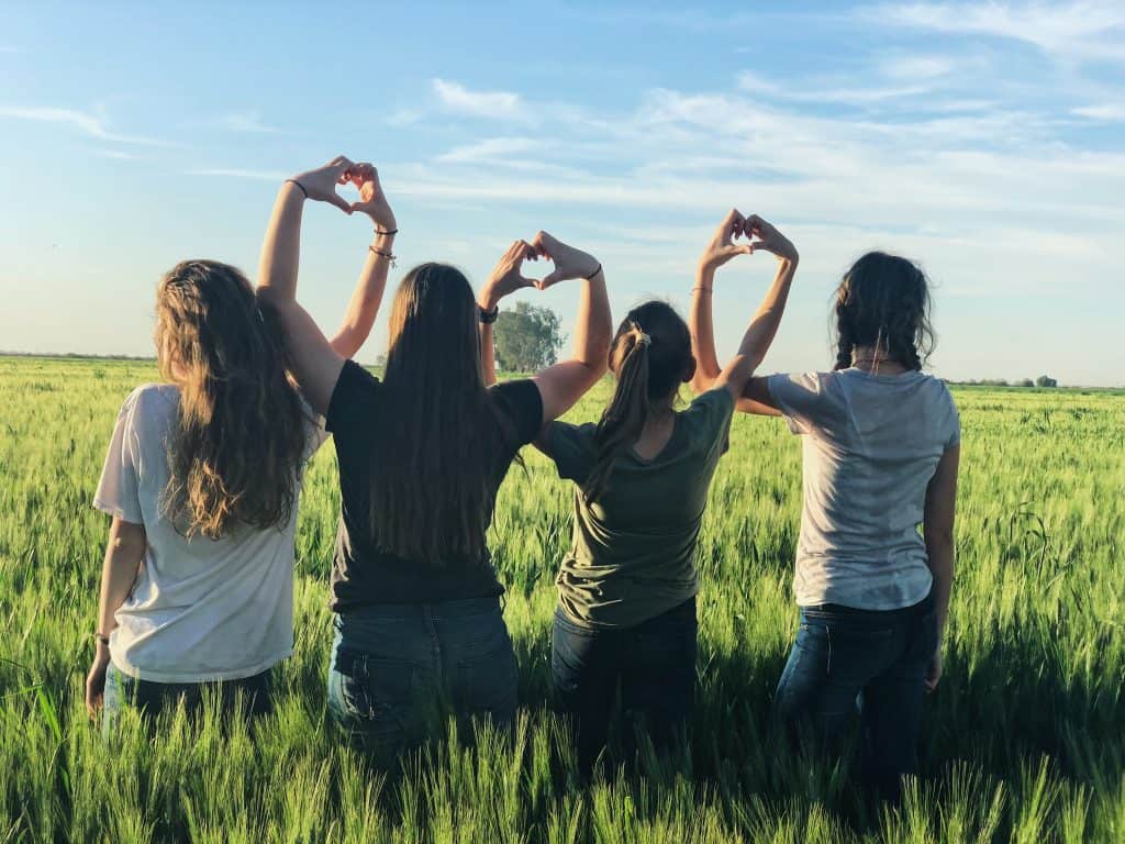 Four girls forming heart shapes with their hands