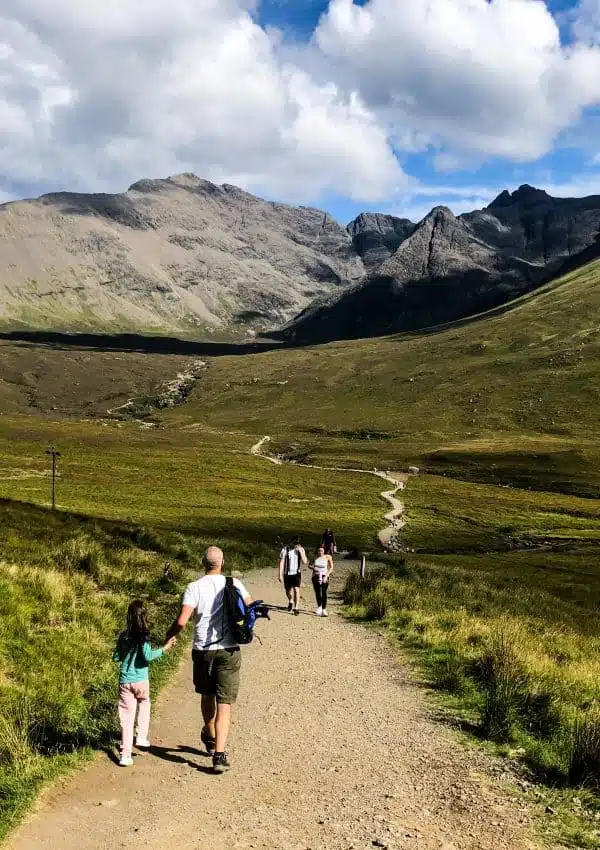 Man and child walking with mountains in the background