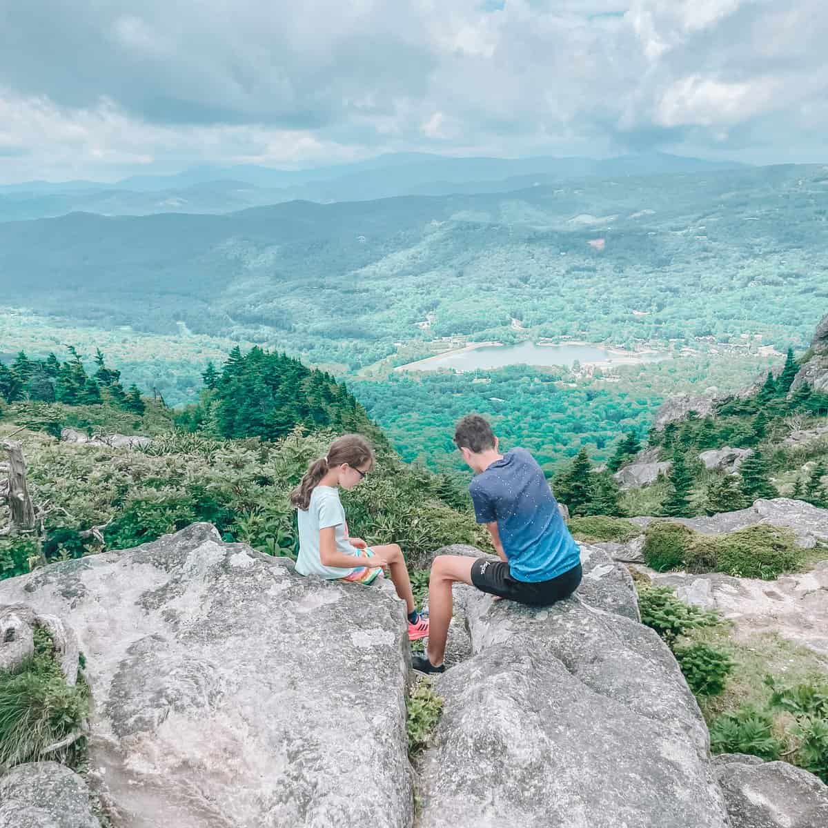 Two children sitting on rocks