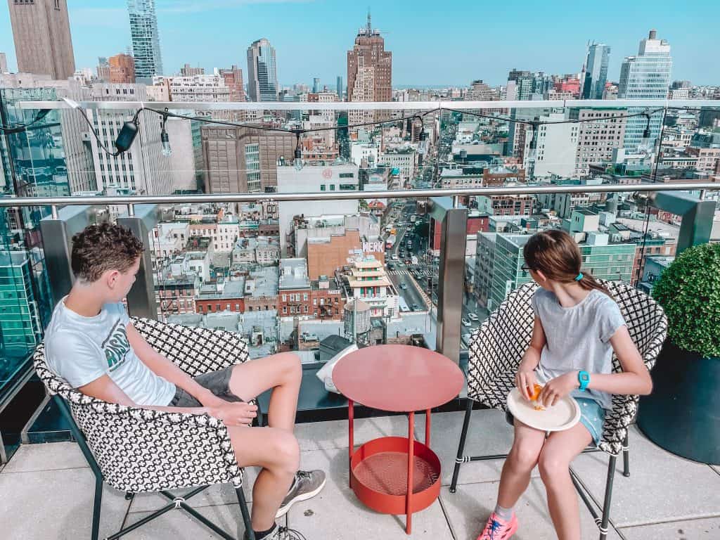 Children sitting at a table and looking at view of New York skyline