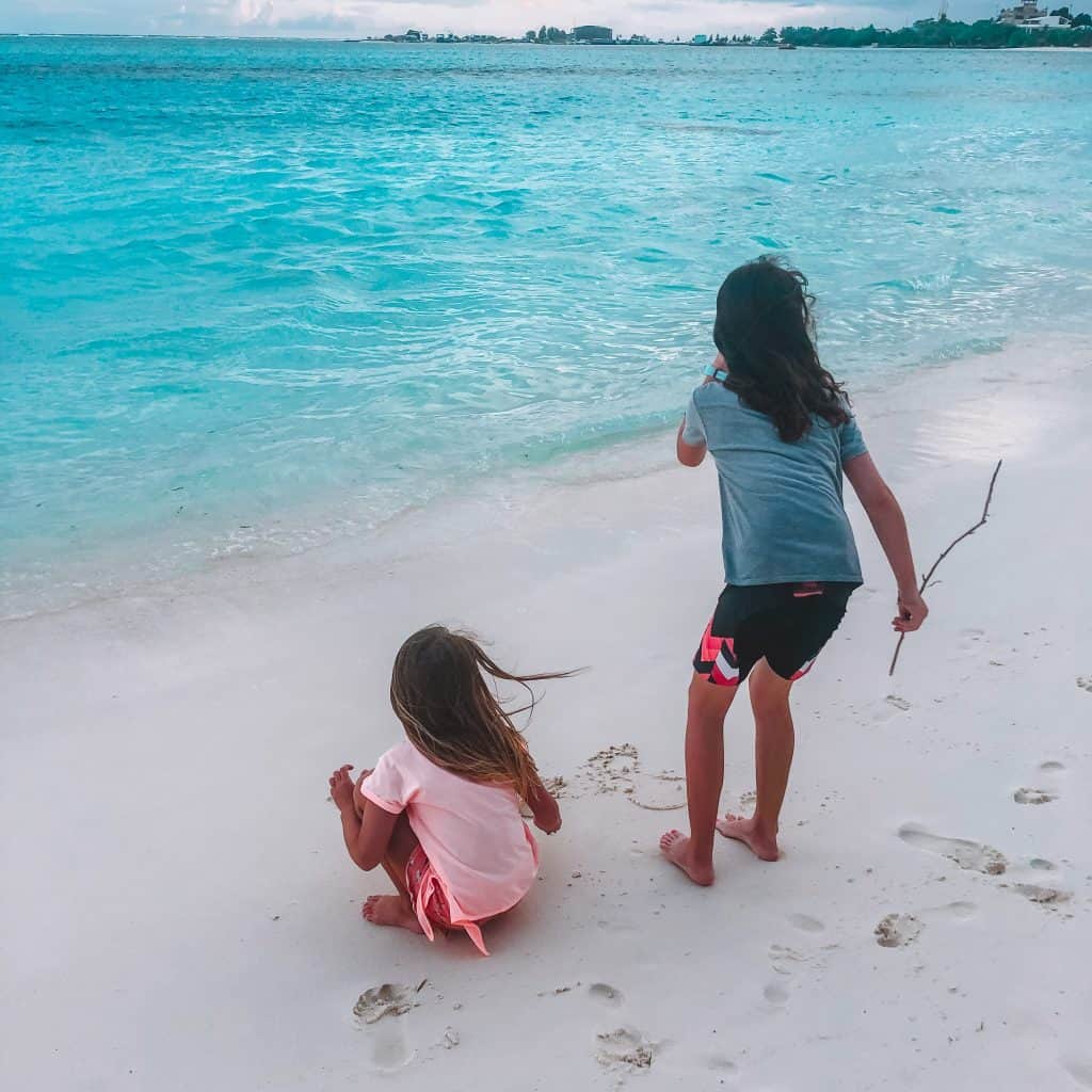 Two girls on a beach looking out to the sea