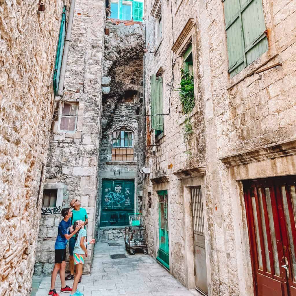 Man and two children looking up at a building 