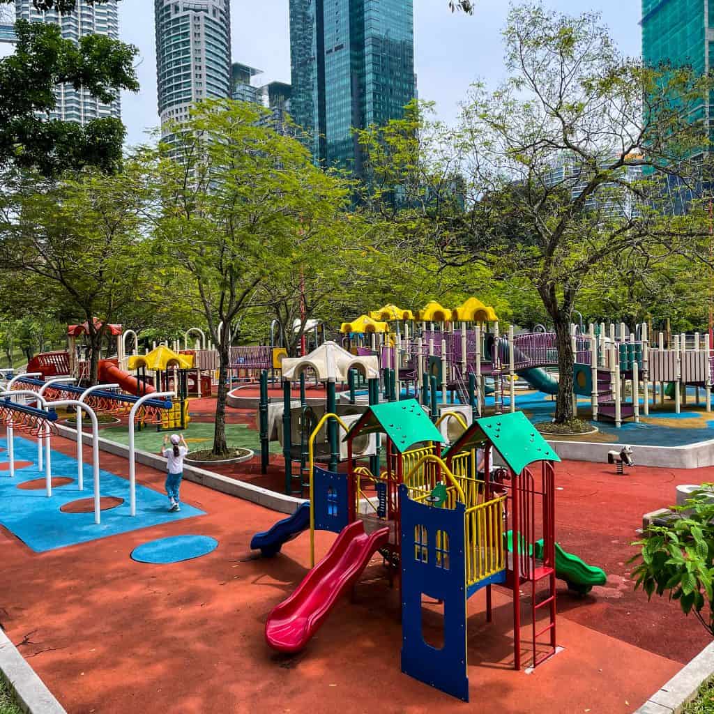 A playground in Kuala Lumpur with skyscrapers behind it