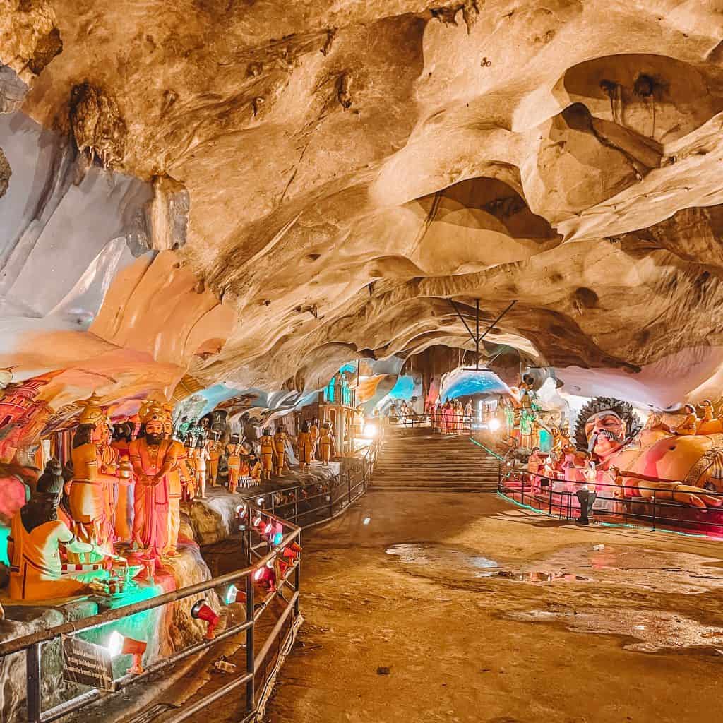 A cave with statues and lighting inside