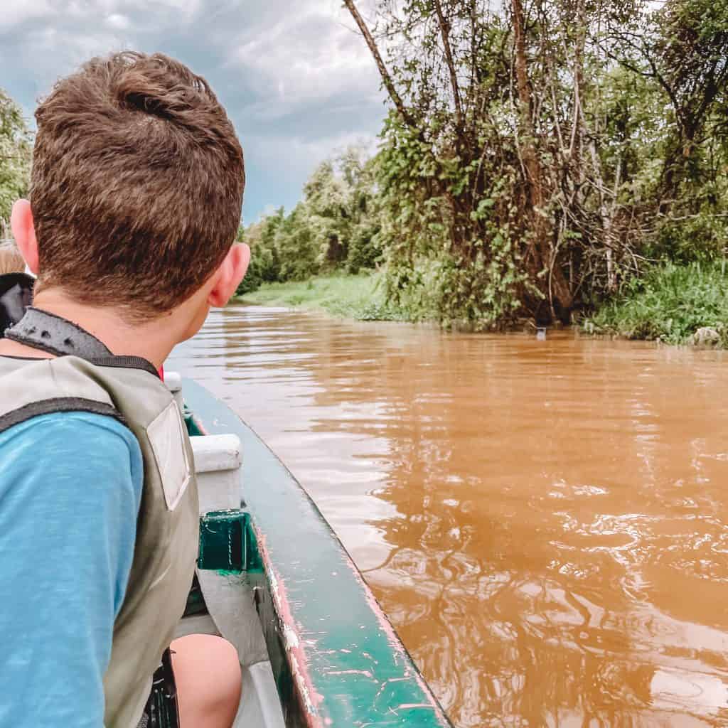 Boy looking out at the river from a boat