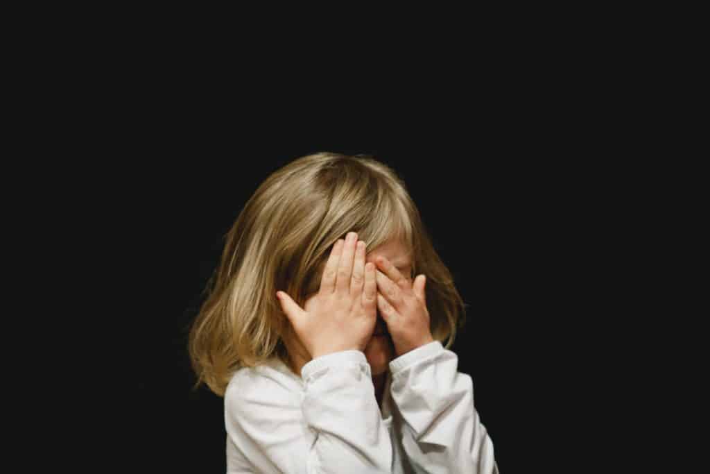 Girl hiding behind her hands