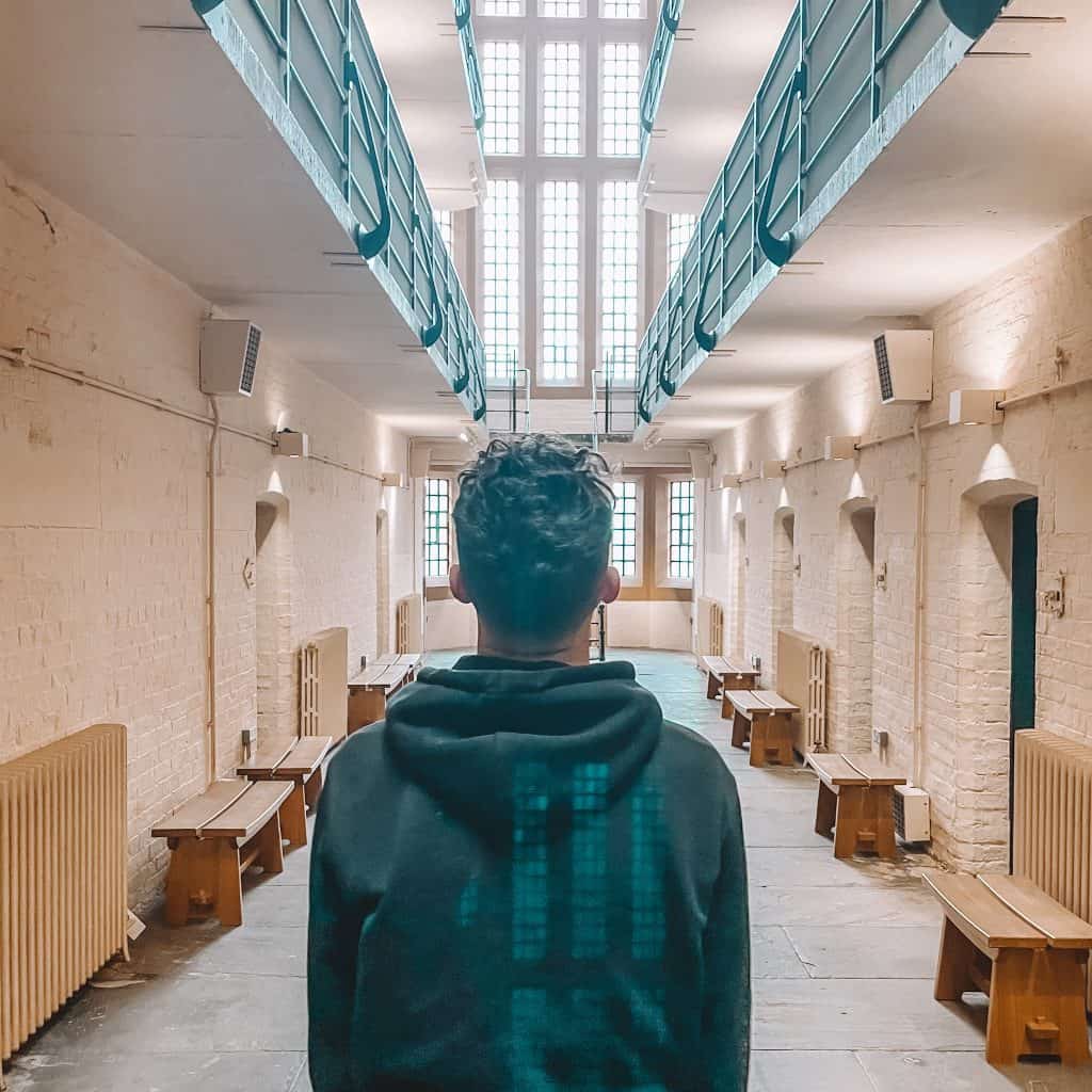 Boy looking out on to prison cells in a prison