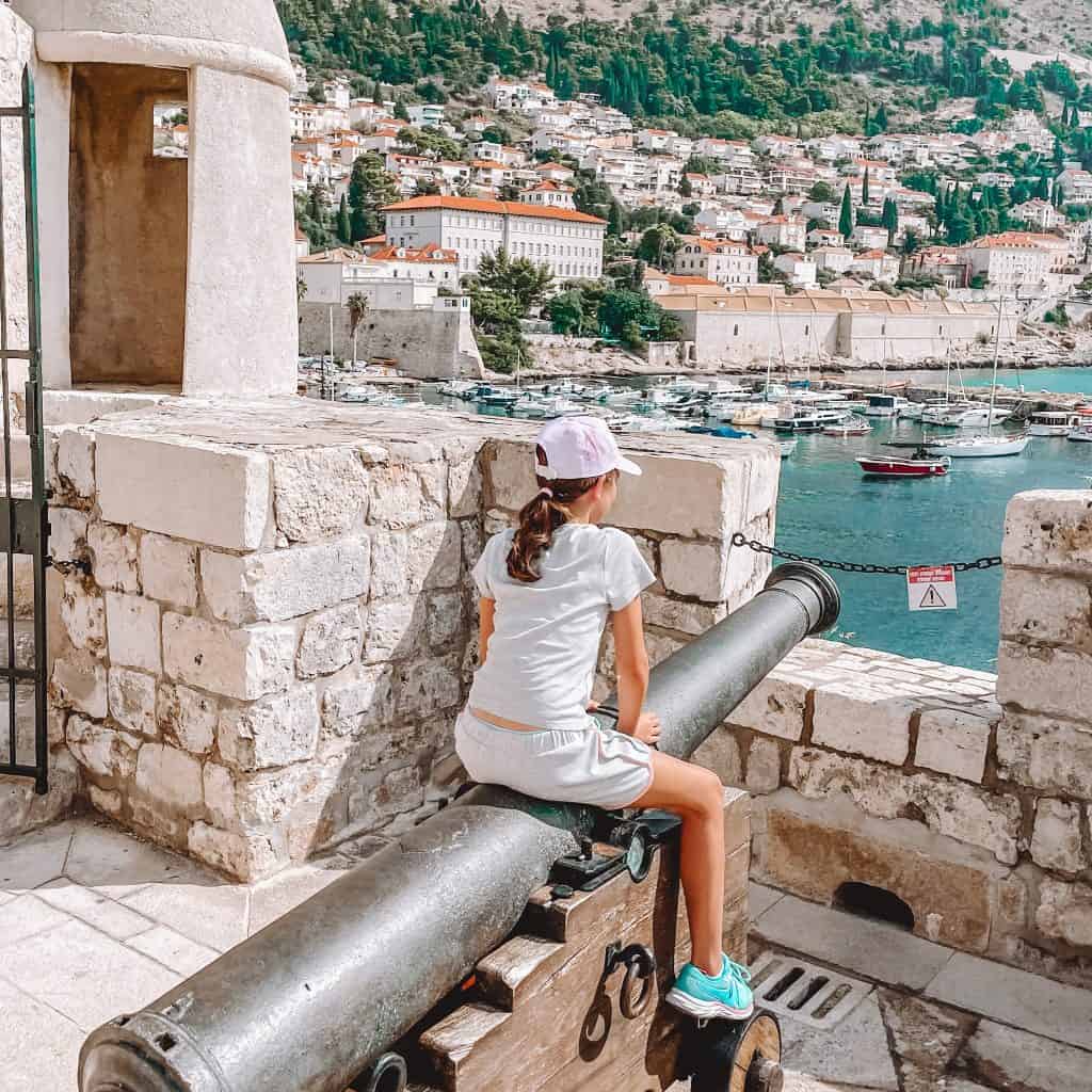 Child sat on a cannon on the city walls in Dubrovnik