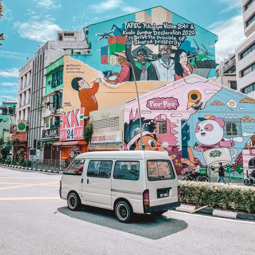 White van driving in front of some colourful graffiti