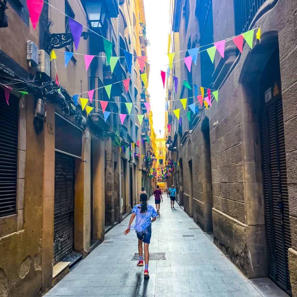 Child running down a narrow street in Barcelona's gothic quarter