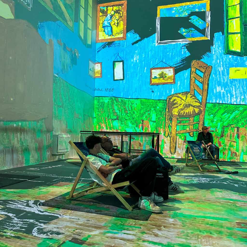 people sitting in deck chairs in immersive art room