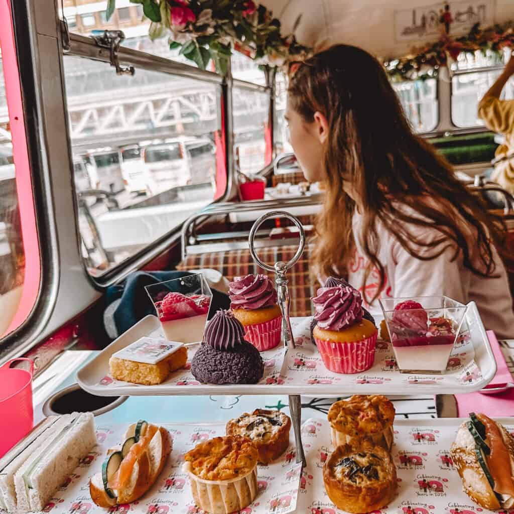 Girl looking out the window of a bus with afternoon tea in front of her