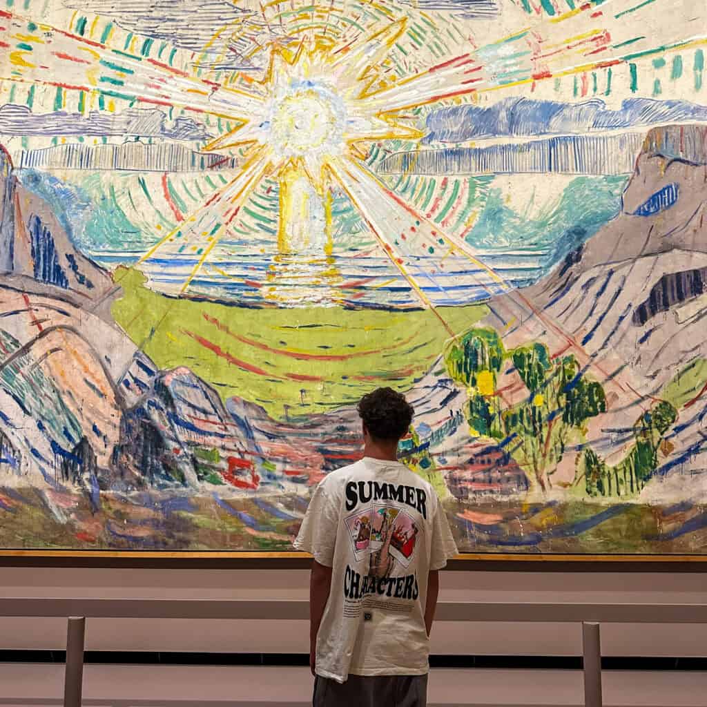 Boy looking at large painting by Munch
