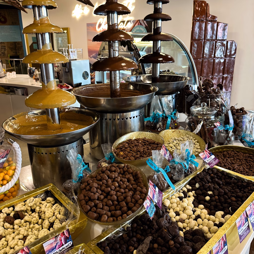 Chocolate fountains, nuts and chocolate in a chocolate shop