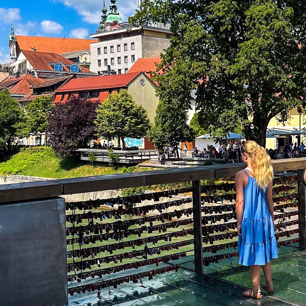 Girl in blue dress on a bridge with 'love locks' attached