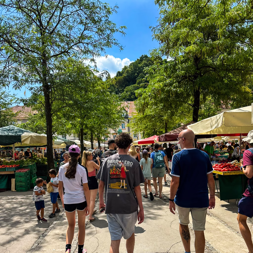 People walking through a market on a sunny day