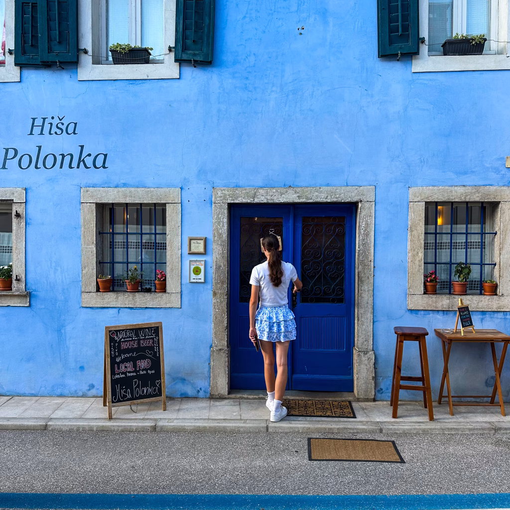 Girl opening a blue door to a blue building